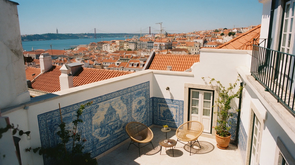 A sunlit courtyard with blue tiles and wicker chairs overlooking the river